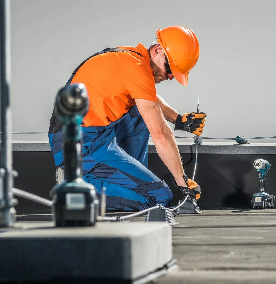 Técnico da O Rei do Para-Raio instalando captor de para-raios na laje de uma edificação